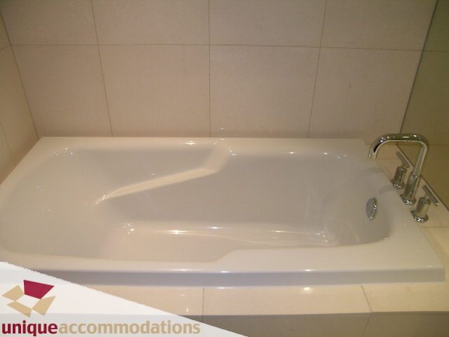 Bright bathroom with modern white bathtub and sleek faucet. - 104 - 1139 West Cordova Street, Vancouver Downtown