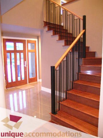 Staircase with wooden steps and black railings leading to upper floor. - 811 Huntingdon Crescent, North Vancouver