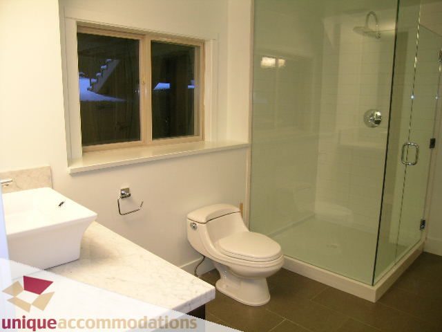 Modern bathroom with marble countertop and glass shower enclosure. - 811 Huntingdon Crescent, North Vancouver