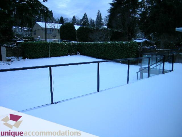 Furnished balcony with snow-covered ground and hedge backdrop. - 811 Huntingdon Crescent, North Vancouver