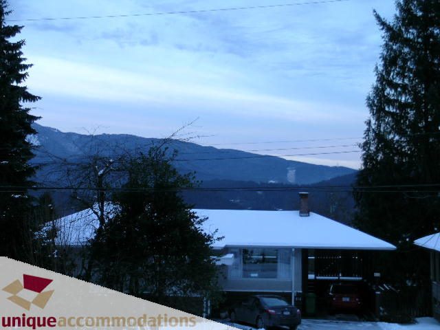 Bright living room with a stunning mountain view and snow-covered landscape. - 811 Huntingdon Crescent, North Vancouver
