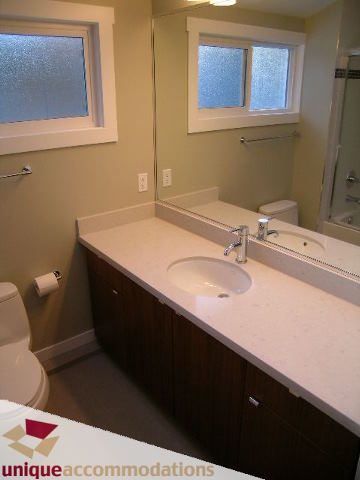 Furnished bathroom with white countertops and dark cabinets. - 388 Hidhurst Place, West Vancouver