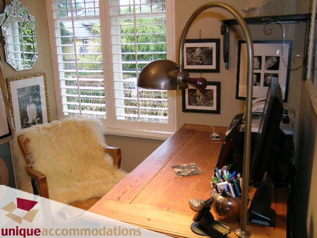 Bright home office with wooden desk, vintage lamp, and fur chair. - 840 16th Street, West Vancouver