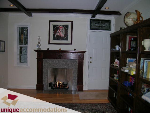 Furnished living room with hardwood floors, fireplace, and bookshelves. - 1055 West 15th Avenue, Vancouver West Side