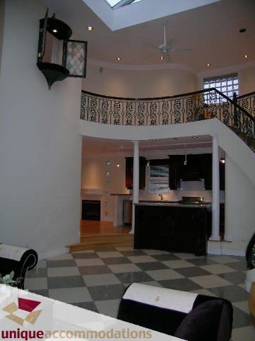 Furnished living room with checkered floor, modern decor, and open staircase. - 1055 West 15th Avenue, Vancouver West Side