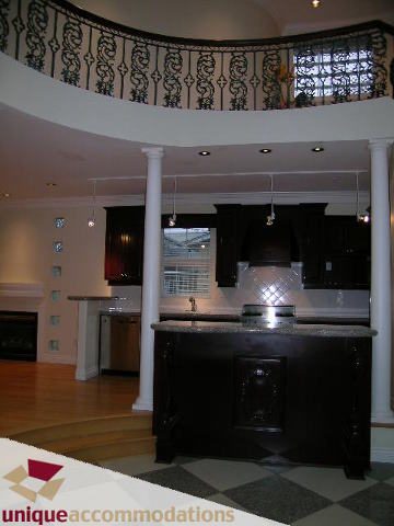 Bright kitchen with dark cabinetry, granite countertops, and a city view. - 1055 West 15th Avenue, Vancouver West Side