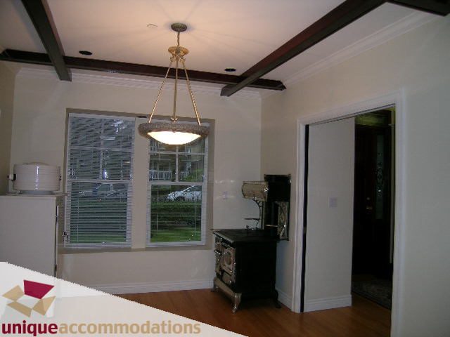Bright living room with hardwood floors, city view, and a vintage stove. - 1055 West 15th Avenue, Vancouver West Side
