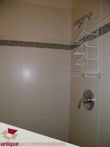 Bathroom with white tile, shower caddy, and modern fixtures. - 1055 West 15th Avenue, Vancouver West Side
