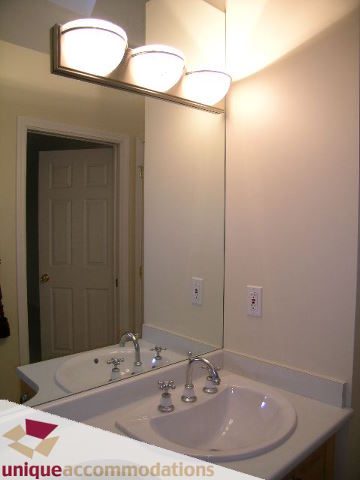 Furnished bathroom with dual sinks and modern lighting fixture. - 1055 West 15th Avenue, Vancouver West Side