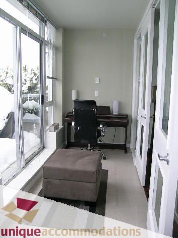 Bright living room with large windows, city view, and comfortable seating. - 702 - 2055 Yukon Street, Vancouver West Side
