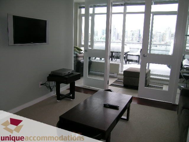 Furnished living room with city view and modern furniture. - 702 - 2055 Yukon Street, Vancouver West Side