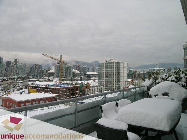 Furnished balcony with snow-covered furniture and city view. - 702 - 2055 Yukon Street, Vancouver West Side