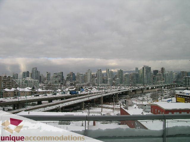 Furnished 2-bedroom condo with a stunning city view and snow-covered rooftops. - 702 - 2055 Yukon Street, Vancouver West Side
