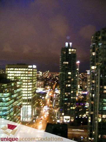Furnished 2-bedroom condo with stunning city view at dusk. - 2701 - 1211 Melville Street, Vancouver Downtown