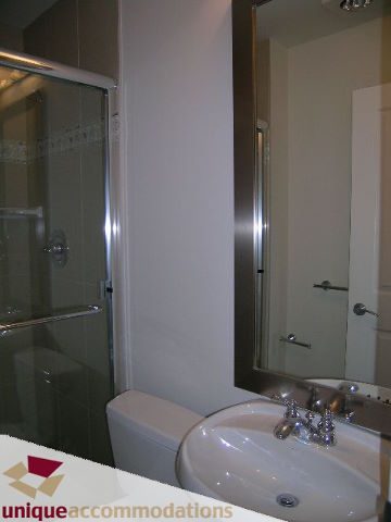 Bathroom with modern sink, glass shower, and sleek countertop. - 2701 - 1211 Melville Street, Vancouver Downtown