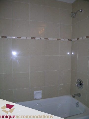 Bathroom with beige tiles, modern shower, and bathtub. - 2701 - 1211 Melville Street, Vancouver Downtown