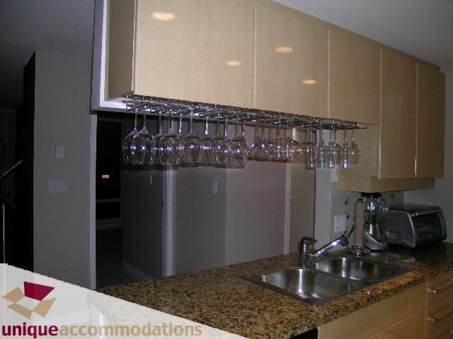 Bright kitchen with granite countertops and wine glass rack, modern design. - 4008 - 1408 Strathmore Mews, Vancouver Downtown