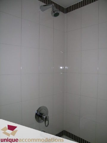 Furnished bathroom with white tile and modern showerhead. - 4008 - 1408 Strathmore Mews, Vancouver Downtown