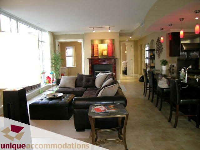 Furnished living room with modern decor, large windows, and a cozy fireplace. - 1702 - 1280 Richards Street, Vancouver Downtown