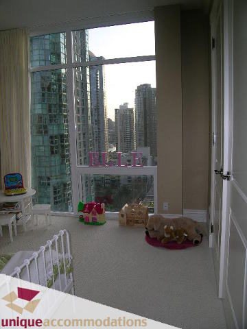 Bright living room with hardwood floors, city view, and cozy dog bed. - 1702 - 1280 Richards Street, Vancouver Downtown