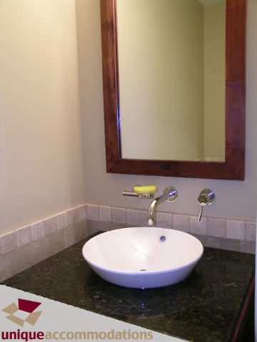 Bathroom with modern sink, granite countertop, and wooden-framed mirror. - 1702 - 1280 Richards Street, Vancouver Downtown