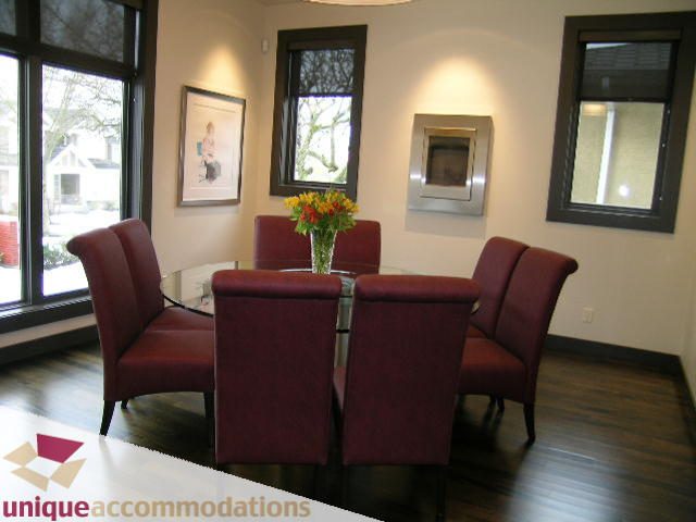 Furnished dining area with dark wood floors, red chairs, and a vase of flowers. - 2429 West 19th Avenue, Vancouver West Side