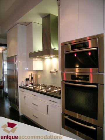 Bright kitchen with stainless steel appliances and white cabinetry, modern design. - 2429 West 19th Avenue, Vancouver West Side
