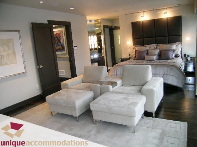 Furnished bedroom with modern furniture, large bed, and white armchairs. - 2429 West 19th Avenue, Vancouver West Side