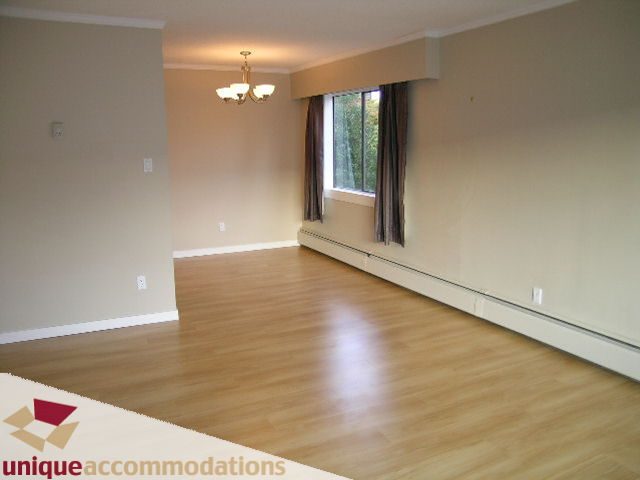 Bright living room with hardwood floors and large window. - 110 - 225 West 3rd Street, North Vancouver