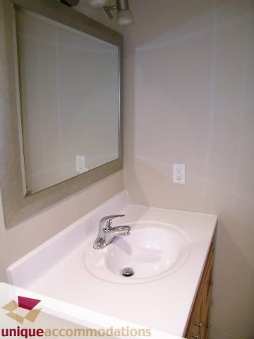 Bathroom with white countertop and sink, modern faucet. - 110 - 225 West 3rd Street, North Vancouver