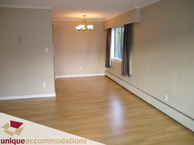 Bright living room with hardwood floors and a large window. - 110 - 225 West 3rd Street, North Vancouver