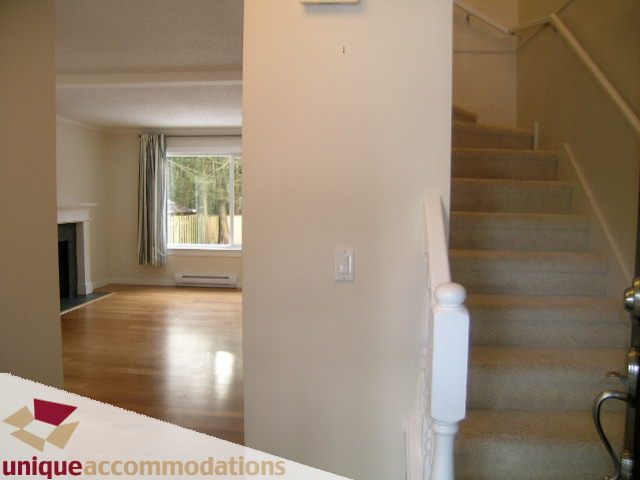 Bright living room with hardwood floors and a staircase leading to the upper level. - 1773 Rufus Drive, North Vancouver