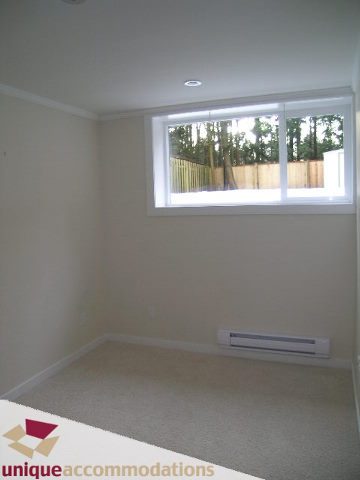 Bright living room with large window and neutral walls. - 1773 Rufus Drive, North Vancouver