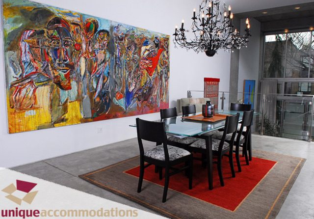 Furnished dining room with abstract art, modern chandelier, and red rug. - 1178 West 7th Avenue, Vancouver West Side