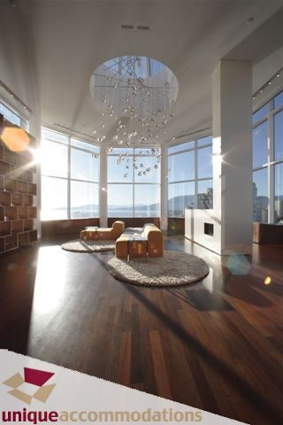 Bright living room with hardwood floors, large windows, and a chandelier, showcasing a city view. - 2601 - 1000 Beach Avenue, Vancouver Downtown