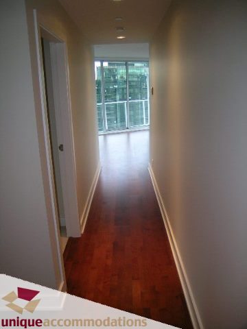 Spacious hallway with hardwood floors and a city view, leading to a bright, open-concept living area. - 2401-1277 Melville, Vancouver Downtown