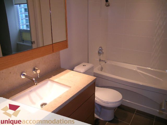 Modern bathroom with sleek countertop and built-in bathtub, offering a clean and functional space. - 2401-1277 Melville, Vancouver Downtown