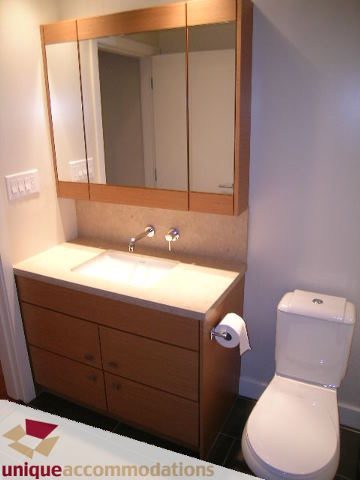 Modern bathroom with light wood cabinets and a sleek countertop. - 2401-1277 Melville, Vancouver Downtown