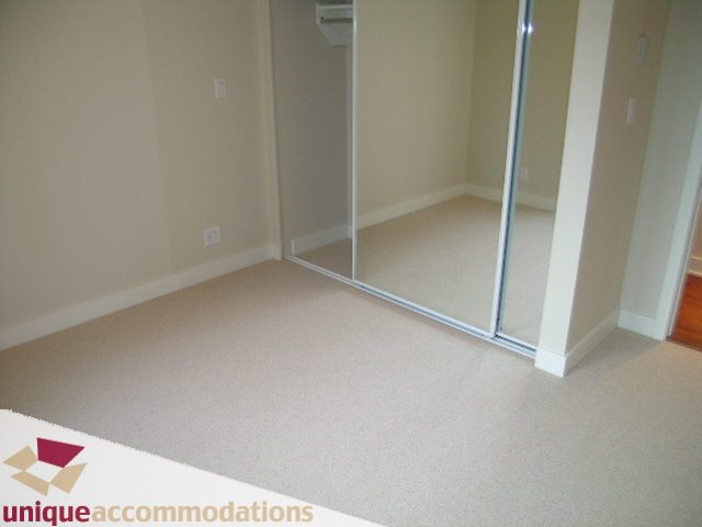 Spacious den with built-in shelving and carpeted flooring, perfect for a cozy reading nook. - 2401-1277 Melville, Vancouver Downtown