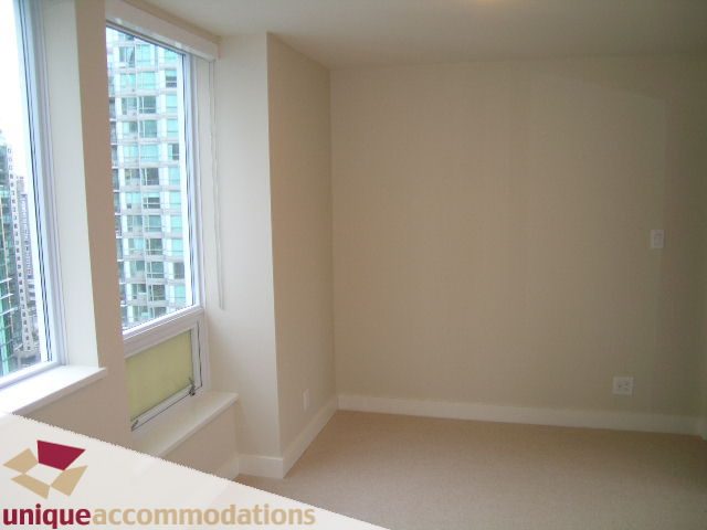 Spacious den with large window offering a city view, light beige walls, and carpeted floor. - 2401-1277 Melville, Vancouver Downtown