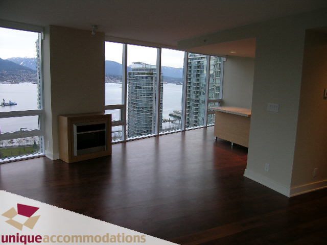 Spacious living room with hardwood floors, city view, and modern furnishings. - 2401-1277 Melville, Vancouver Downtown