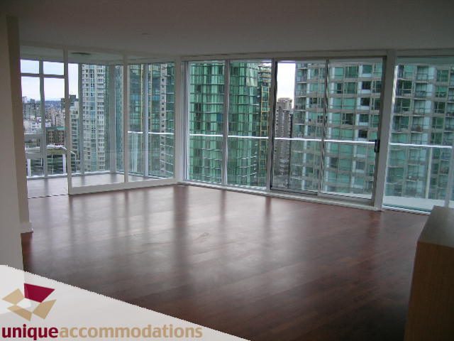 Spacious living room with hardwood floors and a stunning city view. - 2401-1277 Melville, Vancouver Downtown