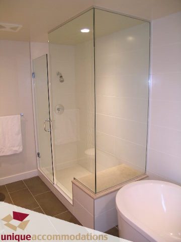 Spacious bathroom with a modern glass-enclosed shower and a freestanding tub. - 2401-1277 Melville, Vancouver Downtown