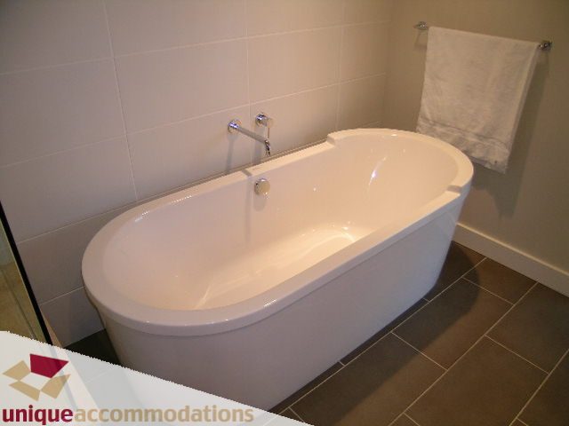 Spacious bathroom with modern bathtub and sleek white fixtures. - 2401-1277 Melville, Vancouver Downtown