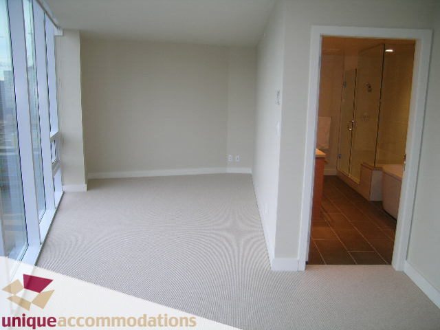 Spacious den with modern carpet, large windows, and a cozy ambiance. - 2401-1277 Melville, Vancouver Downtown