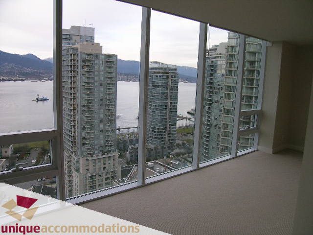 Spacious living room with a stunning city view and modern furnishings. - 2401-1277 Melville, Vancouver Downtown