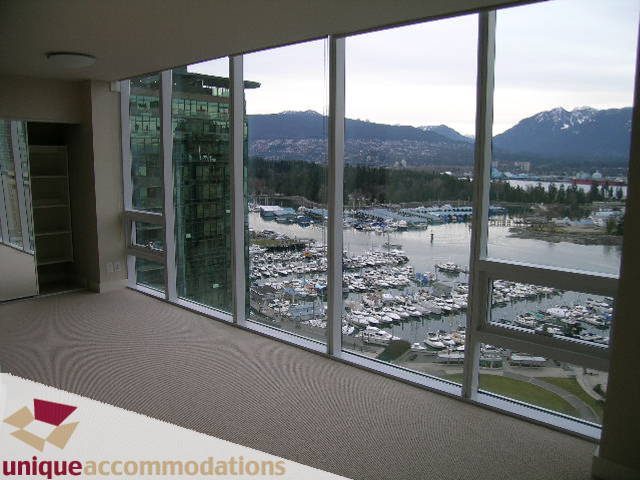 Spacious living room with panoramic city view and marina, featuring large windows and a cozy corner. - 2401-1277 Melville, Vancouver Downtown