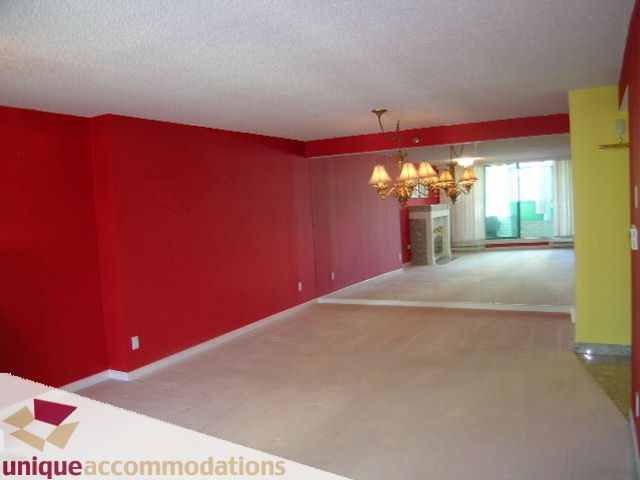 Bright living room with red walls and chandelier, open to kitchen. - 703 - 1132 Haro Street, Vancouver Downtown