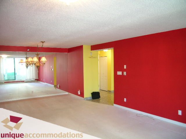 Open living space with red walls, hardwood floors, and a chandelier. - 703 - 1132 Haro Street, Vancouver Downtown