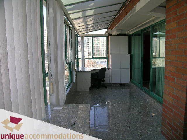 Bright living room with large windows, city view, and modern furnishings. - 703 - 1132 Haro Street, Vancouver Downtown